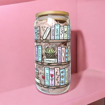 16oz iced coffee glass cup with bookshelf design, perfect for book lovers, shown against a pink background.