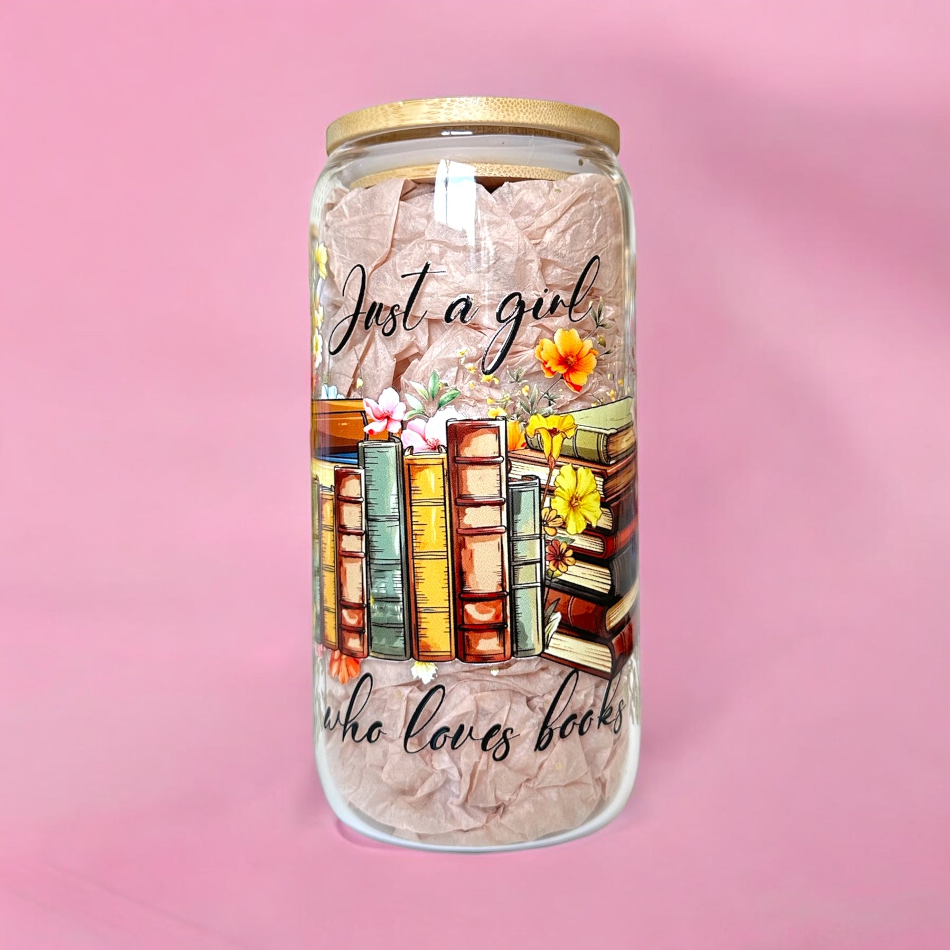 Just a Girl Who Loves Books Iced Coffee Glass Cup with floral design and stack of books on a pink background